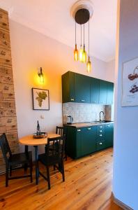 a kitchen with green cabinets and a table and chairs at Apartament Riesling in Zielona Góra