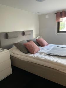 a bedroom with a bed with pink pillows on it at Hults-Boaryd Golf och B&B in Hult +15 photos