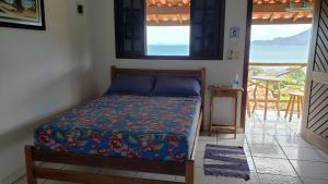 een slaapkamer met een bed en uitzicht op de oceaan bij Chalé & Suítes Mar Aberto in Ilhabela