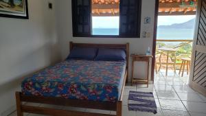Un dormitorio con una cama con vista al mar. en Chalé & Suítes Mar Aberto, en Ilhabela