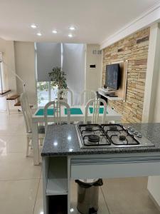 a kitchen with a stove and a table with chairs at BRISAS DEL MAR in Santa Teresita