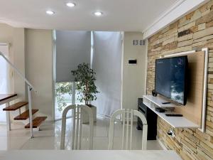 a living room with a tv on a brick wall at BRISAS DEL MAR in Santa Teresita