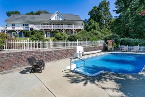 a swimming pool with two chairs and a house at Brook Knoll · NEW! Beautiful Mtn Retreat w/Pool Near Asheville! in Weaverville