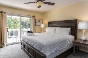 a bedroom with a bed with a ceiling fan and a window at Brook Knoll · NEW! Beautiful Mtn Retreat w/Pool Near Asheville! in Weaverville +30 photos