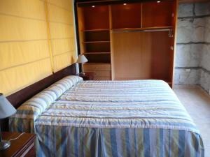 1 dormitorio con cama y armario en Cabañas El Pedregal en Sierra de los Padres