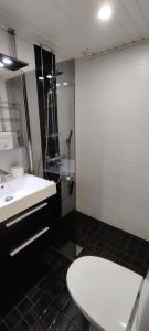 a bathroom with a white sink and a toilet at Freshly renovated apartment, perfect for couple in Kerava