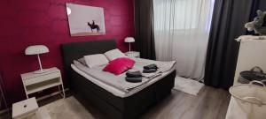 a small bedroom with a bed with pink pillows at Freshly renovated apartment, perfect for couple in Kerava
