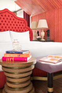 a pile of books on a table in a bedroom at Maison 140 Beverly Hills in Los Angeles