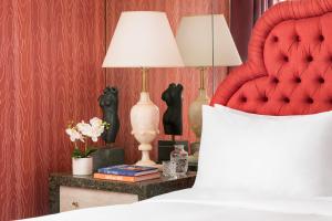 Schlafzimmer mit einem roten Bett und einer Lampe auf dem Tisch in der Unterkunft Maison 140 Beverly Hills in Los Angeles