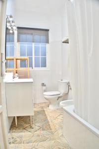 a white bathroom with a toilet and a sink at Gran apartamento en San Bartolomé in Seville