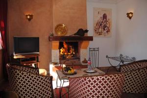 sala de estar con chimenea, mesa y sillas en Les Tourmalines, en Ouarzazate