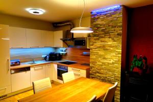 cocina con mesa de madera y pared de piedra en Appartements Nassfeld LUX, en Sonnenalpe Nassfeld