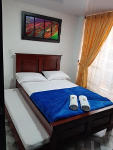 une chambre avec un lit avec deux pantoufles dessus dans l'établissement Apartamento Refugio Cafetero, à Santa Rosa de Cabal