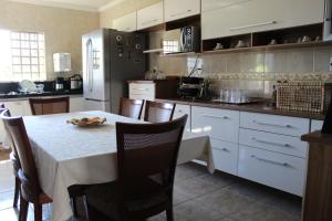 a kitchen with a table and a refrigerator at RECANTO JK in Taguatinga