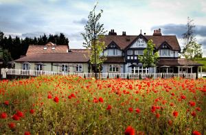 a red brick building with a bunch of flowers in front of it at The Red Lion Inn by Chef & Brewer Collection in Todwick