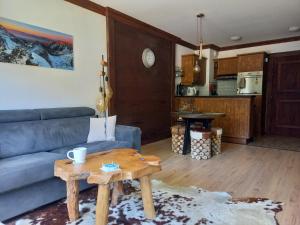 uma sala de estar com um sofá azul e uma mesa em appartement de standing Arc 1950 em Bourg-Saint-Maurice