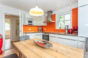 eine Küche mit einem Holztisch mit einer Schüssel Tomaten darauf in der Unterkunft Ferienwohnung Weitblick in Saalfelden am Steinernen Meer