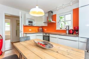 una cocina con una mesa de madera con un tazón de tomates. en Ferienwohnung Weitblick, en Saalfelden am Steinernen Meer