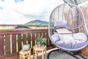 a wicker rocking chair sitting on a balcony at Ferienwohnung Weitblick in Saalfelden am Steinernen Meer +7 photos