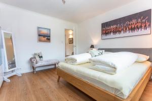 a bedroom with white walls and a bed with white pillows at Ferienwohnung Weitblick in Saalfelden am Steinernen Meer