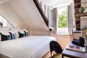 - une chambre avec un lit blanc et une fenêtre dans l'établissement Hôtel La Canopée, à Paris