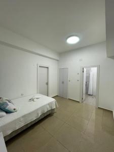 a white room with a bed and a hallway at Laila's studio2 in Haifa