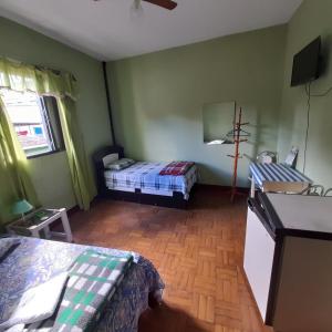 sypialnia z 2 łóżkami i drewnianą podłogą w obiekcie Hotel Shangri-la w mieście Três Corações