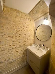 a bathroom with a sink and a mirror at Chambres d'hôtes Le Maroni in Courseulles-sur-Mer