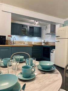 - une cuisine avec une table et des bols dans l'établissement Chambres d'hôtes Le Maroni, à Courseulles-sur-Mer