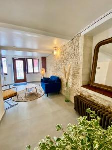 - un salon avec un canapé bleu et un miroir dans l'établissement Chambres d'hôtes Le Maroni, à Courseulles-sur-Mer