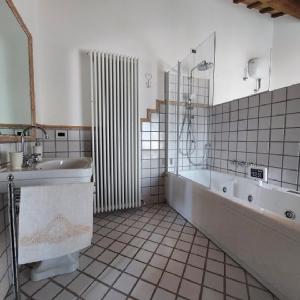 y baño con bañera, lavamanos y bañera. en Il Pozzo di Vivalpa en Serra deʼ Conti