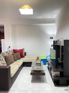 - un salon avec un canapé et une télévision dans l'établissement Apartamento F.A, à Pedrógão