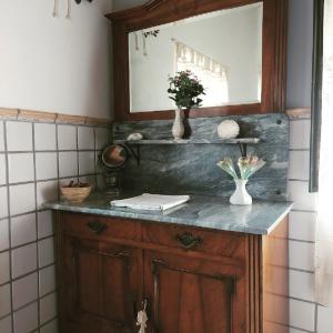 a bathroom with a vanity with a mirror and flowers at Il Pozzo di Vivalpa in Serra deʼ Conti +39 photos