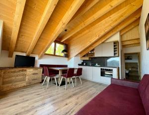 a kitchen and living room with a table and chairs at Sartu Apartments in San Vigilio Di Marebbe