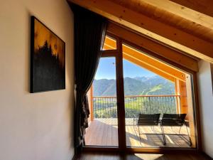 a room with a large sliding glass door with a balcony at Sartu Apartments in San Vigilio Di Marebbe