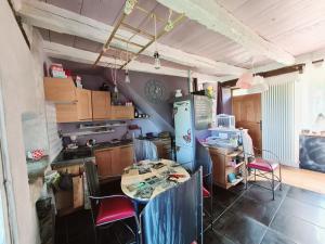 Una cocina con una mesa y sillas en una habitación. en Ma Maison Charme et déco atypique SophieAndCo, en Bozouls