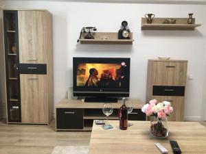 sala de estar con TV y mesa con flores en Magheru cozy new apartament 2 rooms, en Bucarest