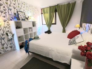 een slaapkamer met een groot wit bed met rode kussens bij Charming Sunset View Apt Heater Pool Costa Adeje in Adeje