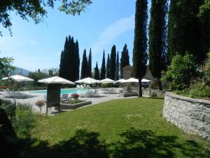a garden with umbrellas and a swimming pool at Le Gret in Subbiano