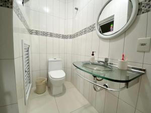 a bathroom with a sink and a toilet and a mirror at Apto Beira Mar 3D in Capão da Canoa +16 photos