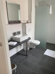 a bathroom with a sink and a toilet at Haus Baaken in Heide