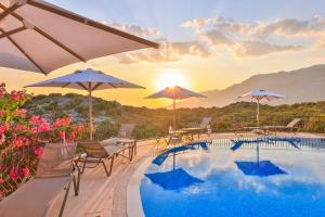 a swimming pool with chairs and umbrellas on a resort at Hill House Adult Only in Kaş