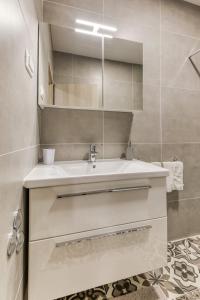 La salle de bains est pourvue d'un lavabo blanc et d'un miroir. dans l'établissement Apartmani Leptir, à Rakovica