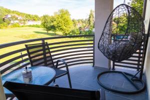 einen Tisch und Stühle auf einem Balkon mit Aussicht in der Unterkunft Apartmani Leptir in Rakovica