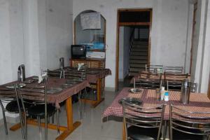 comedor con mesas y sillas y TV en Goroomgo Hotel Shivay Near Kausani Chouraha - Mountain View - Excellent Customer Service en Kausani