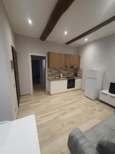 sala de estar con cocina y suelo de madera en Alloggi di porta po, en Cremona