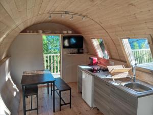 a small kitchen with a sink and a table at les insolites du villaret in Saint-Vincent-les-Forts