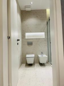 ティラナにあるPalmar Innの白いトイレと洗面台のあるバスルーム
