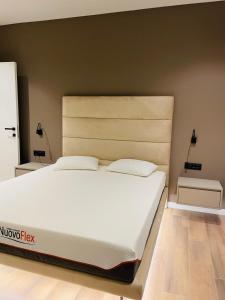 ティラナにあるPalmar Innの部屋にある大きな白いベッドのある寝室