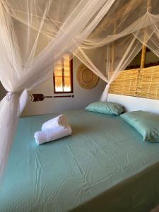 a bedroom with a bed with a canopy at Chalé Sienna Ar condicionado Pousada 35knots Brasil in Luis Correia